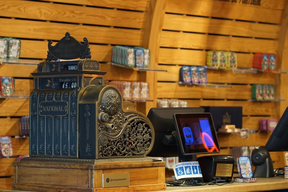 A cash register sits on a modern retail store checkout counter, illustrating in-person point-of-sale hardware.